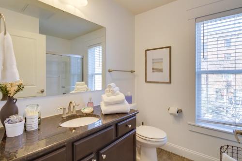 a bathroom with a sink and a toilet and a mirror at Walkable Lynchburg Condo with Private Balcony in Lynchburg