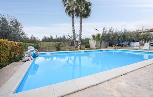 a large blue swimming pool with a teddy bear sitting next to it at 3 Bedroom Nice Apartment In Comiso in Comiso