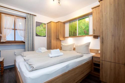 een slaapkamer met een groot bed met witte lakens bij Ferienwohnung Rosendahl in Reit im Winkl