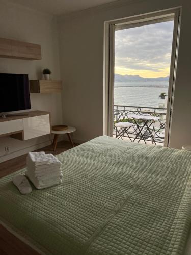 een slaapkamer met een bed en uitzicht op de oceaan bij Croisette Palais Miramar - sea view in Cannes