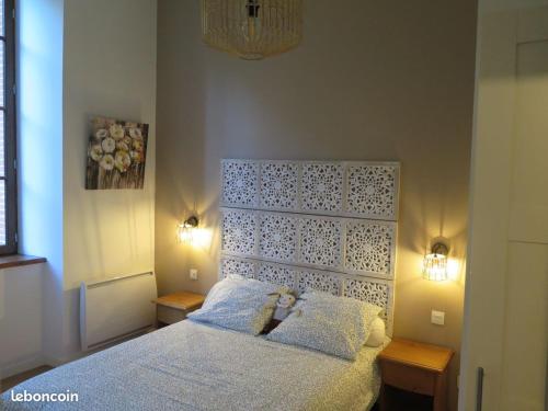 Un dormitorio con una cama blanca con dos luces. en "Le Desman" Confortable T2 à la montagne face aux thermes RANDO, CURE, en Aulus-les-Bains