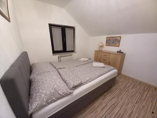 a bedroom with a bed and a dresser and a window at Receptiva BL in Banja Luka