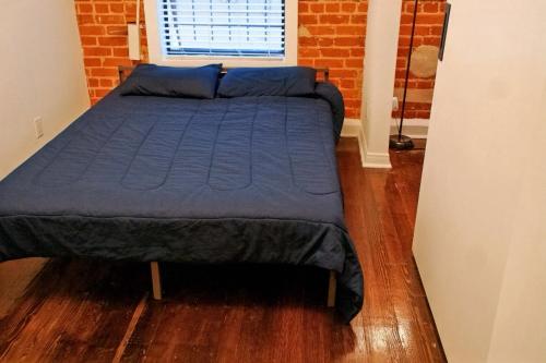 a bed in a bedroom with a brick wall at City Escape- 5 Mins to LACMA! in Los Angeles