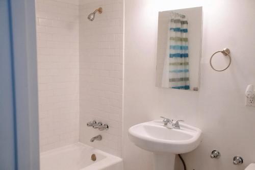 a white bathroom with a sink and a shower at City Escape- 5 Mins to LACMA! in Los Angeles