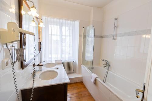 a white bathroom with a sink and a shower at Schloss Neckarbischofsheim in Neckarbischofsheim