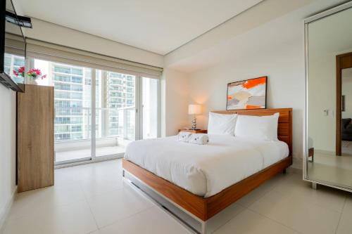 um quarto com uma cama grande e uma janela grande em Awesome 2BR with balcony in Costa del Este na Cidade do Panamá