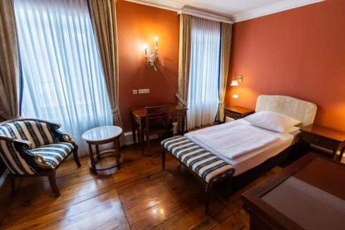 a hotel room with a bed and a chair at Schloss Neckarbischofsheim in Neckarbischofsheim