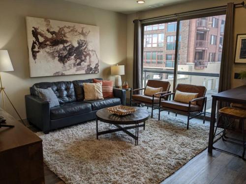 a living room with a leather couch and chairs at Modern State 209 Just Blocks Away From The Bay in Traverse City
