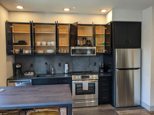a kitchen with black cabinets and stainless steel appliances at Modern State 209 Just Blocks Away From The Bay in Traverse City