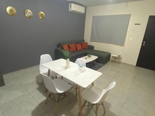 a living room with a white table and white chairs at Departamento Piso 1 in Mazatlán