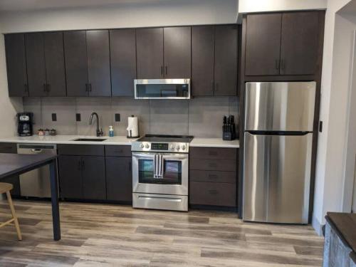a kitchen with stainless steel appliances and wooden cabinets at Modern Downtown Condo in Traverse City