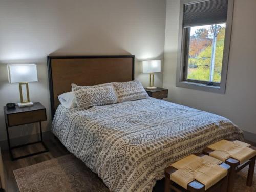 a bedroom with a large bed with two lamps and a window at Modern Condo 210 Just Blocks from Lake Michigan in Traverse City