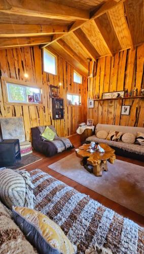 ein Wohnzimmer mit einem Sofa und einem Tisch in der Unterkunft Cabaña en Valdivia in Valdivia
