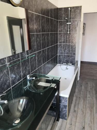 une salle de bain avec un lavabo, une baignoire et un miroir dans l'établissement 60m2 à 300m de la plage - 6 pers - linge compris - Wifi gratuit, à Berck-sur-Mer
