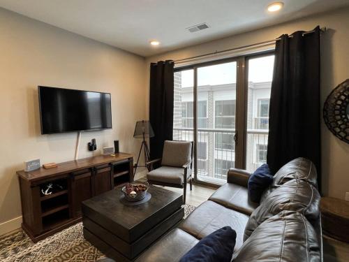 a living room with a couch and a flat screen tv at Trendy Downtown Condo-Walk to it ALL Capri 315 in Traverse City
