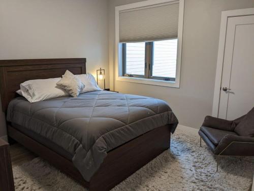 a bedroom with a bed and a chair and a window at Trendy Downtown Condo-Walk to it ALL Capri 315 in Traverse City