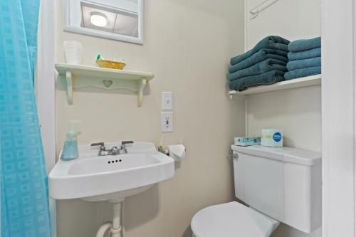 a white bathroom with a toilet and a sink at Beach Motel and Suites in Old Orchard Beach