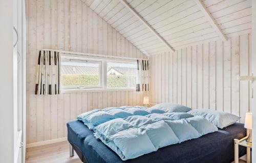 ÅrøsundにあるBeautiful Home In Haderslev With Wifiのベッドルーム(青い枕付きの大型ベッド1台付)