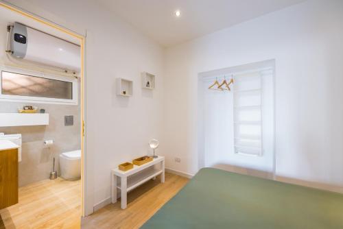 un bagno con uno specchio, un lavandino e un water di Corte Belvedere a Napoli