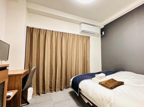 a hotel room with a bed and a desk and a television at GR HONKAWA - Global Resort Hotel in Hiroshima