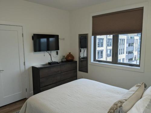 a bedroom with a bed and a flat screen tv at Downtown Traverse City Capri Condo 316 in Traverse City