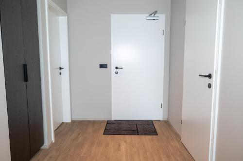 a hallway with white doors and a wooden floor at New apartment downtown Akureyri in Akureyri