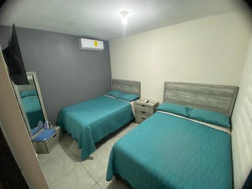a small room with two beds and a mirror at Departamento Piso 1 in Mazatlán