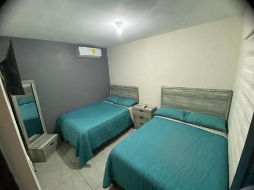 a small room with two beds and a mirror at Departamento Piso 1 in Mazatlán