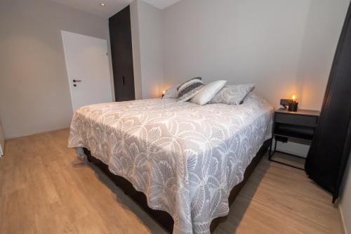a bedroom with a bed and a night stand with a table at New apartment downtown Akureyri in Akureyri