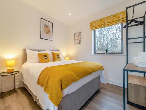 a bedroom with a large bed and a window at The Haywain in East Bergholt