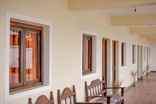 a row of benches in a room with windows at Hostal La Vidala in Tafí del Valle