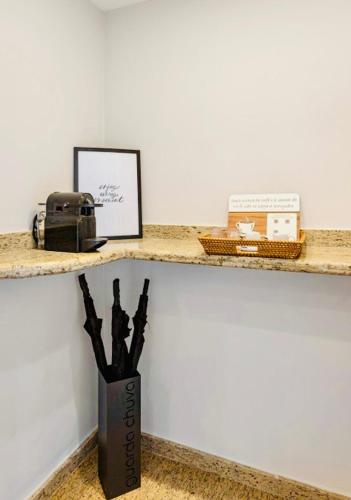 a black vase sitting on a counter next to a shelf at Maravilhoso apartamento na orla da Barra da Tijuca in Rio de Janeiro