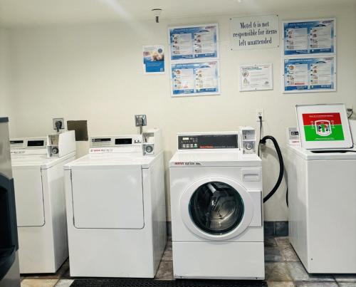 a laundry room with three washing machines and a washer at Motel 6-Santa Ana, CA in Santa Ana