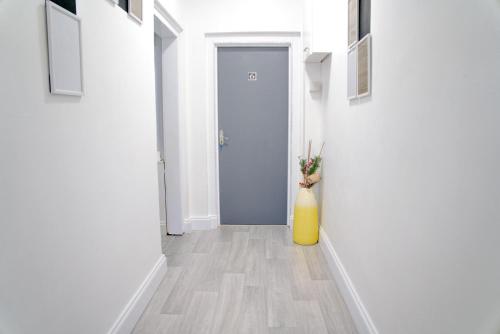 a hallway with a yellow vase next to a door at 1 bedroom flat Halesowen in Halesowen