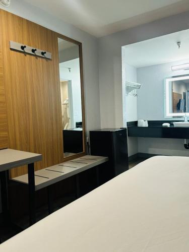 a bedroom with a mirror and a bed and a sink at Motel 6-Santa Ana, CA in Santa Ana