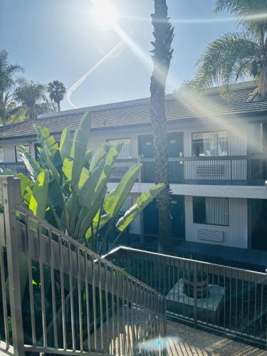 a house with a fence and a palm tree at Motel 6-Santa Ana, CA in Santa Ana