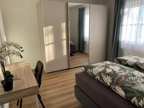 a room with a bed and a table and a mirror at Außergewöhnliche Ferienwohnung in modernen Styl in Weiding