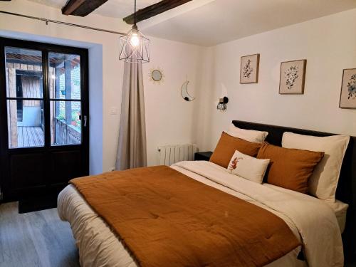 1 dormitorio con 1 cama grande con manta naranja en Grand gîte dans maison alsacienne historique, en Gueberschwihr