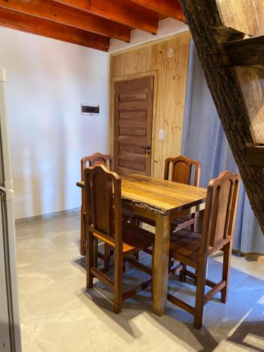 a wooden table and chairs in a room at Hospedaje El Tucan in Puerto Iguazú