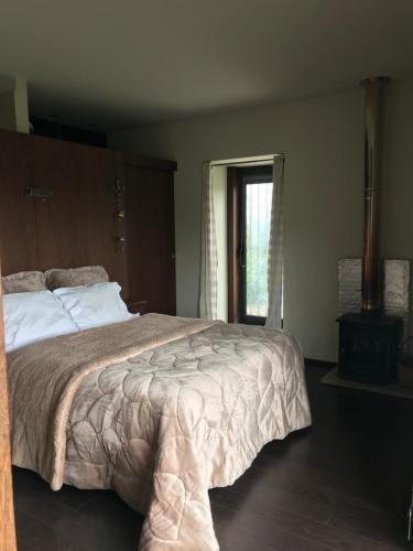 ein Schlafzimmer mit einem großen Bett und einem Fenster in der Unterkunft Casa Nova in Guimarães