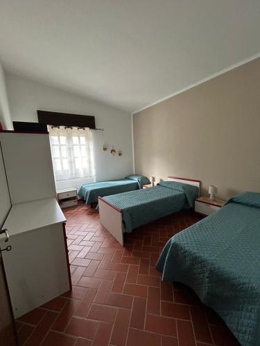 Habitación con 3 camas y ventana en Villetta Oddoene, en Dorgali