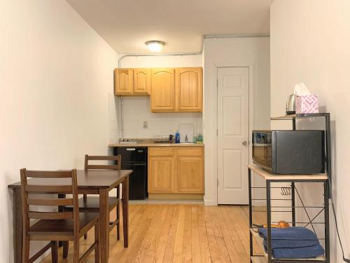 Una pequeña cocina con una mesa y un microondas. en Shered bathroom 4 SofaBed + loftbed + kitchen, en Nueva York