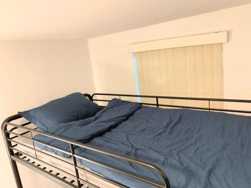 Una cama con una manta azul en un dormitorio en Shered bathroom 4 SofaBed + loftbed + kitchen, en Nueva York