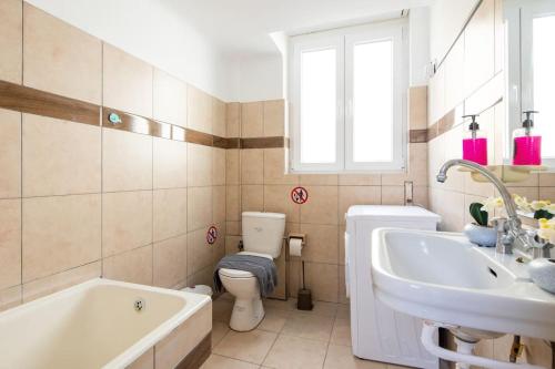uma casa de banho com uma banheira, um WC e um lavatório. em Prestige apartment in the heart of Athens ( 1 ) em Atenas