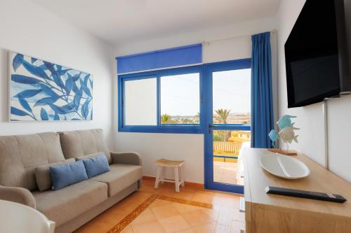 uma sala de estar com um sofá e uma televisão em Astarita SUN em Costa Calma