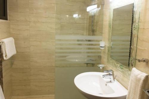 a bathroom with a sink and a mirror at SAK Suites in Rujm ash Sharāʼirah