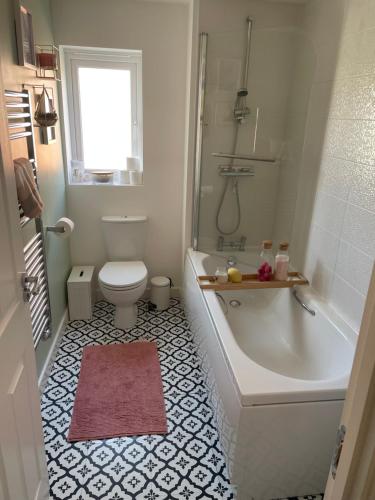 y baño con bañera, aseo y lavamanos. en 2 bedroom house, en Seacroft