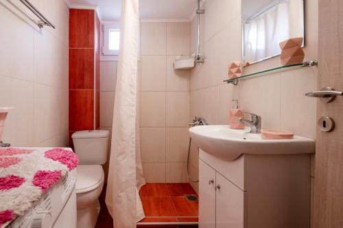 a small bathroom with a sink and a toilet at Emi's beach apartment in Nea Kalikratia