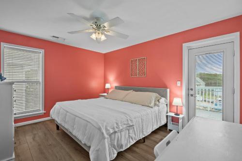 a red bedroom with a bed and a ceiling fan at Golden Hour on Greenville- 1.5 blocks to beach, Pet Friendly, & No Hidden Fees!! in Carolina Beach