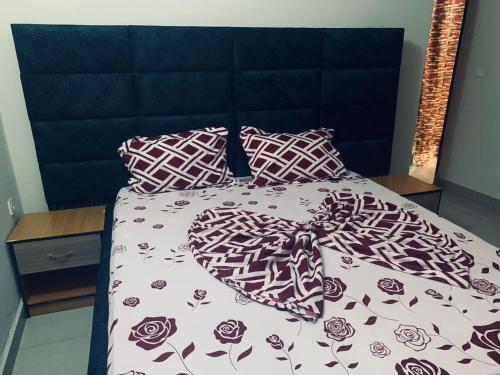 a bed with purple and white sheets and pillows at Appartement meublé , Bonamoussadi, Douala-Vanguard's signature Suite in Douala